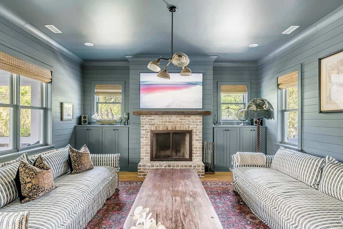 beach style family room with a fireplace