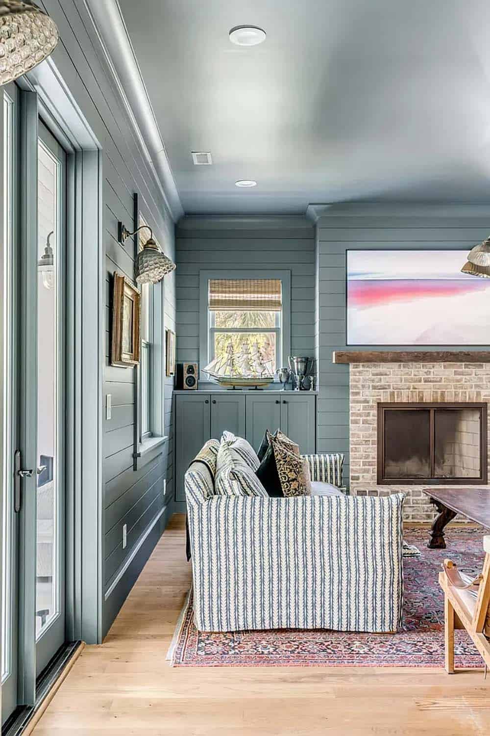 beach style family room with a fireplace