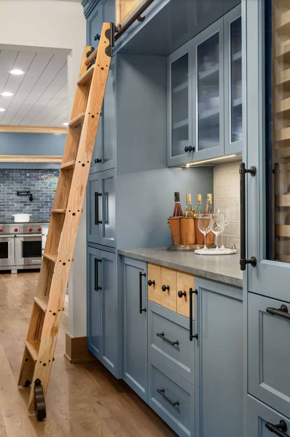 coastal style home bar with a rolling library ladder