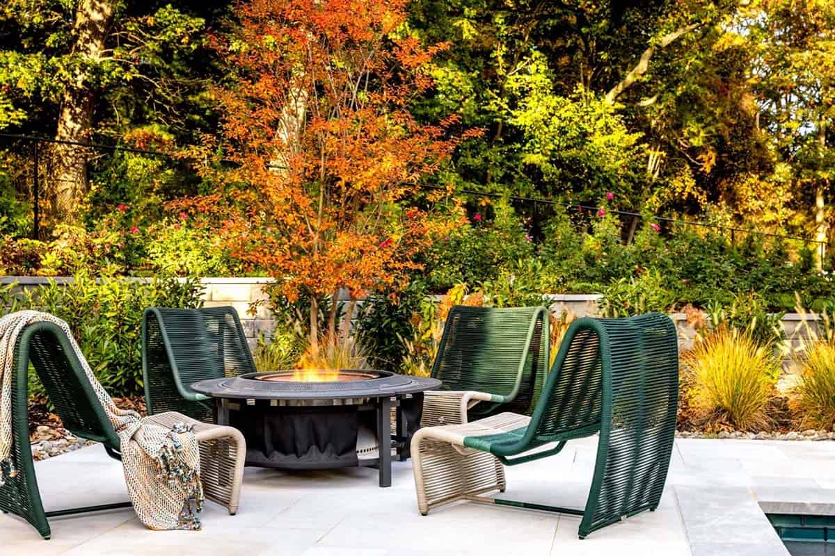 farmhouse style patio with a fire pit and chairs