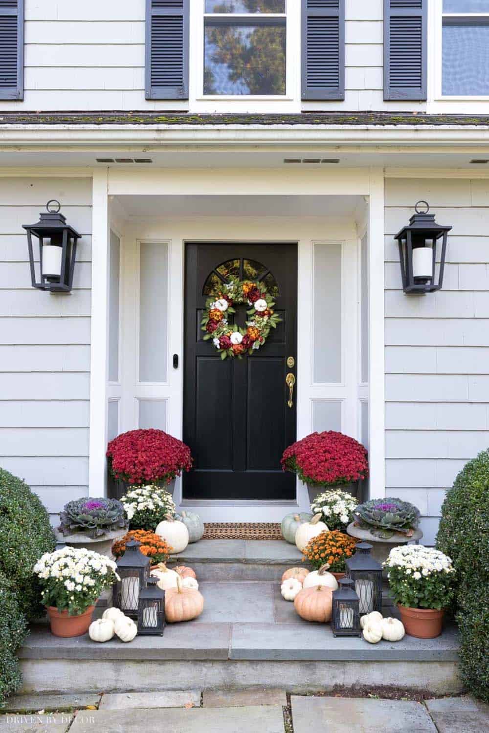 front porch steps with fall decorations and lanterns