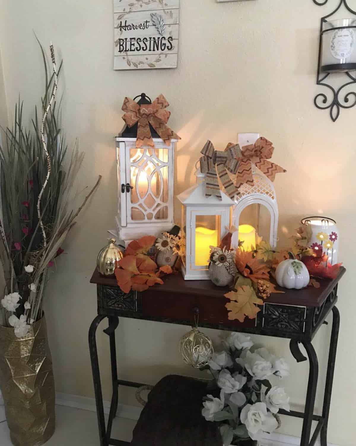 entry table decorated for fall with lanterns and pumpkins