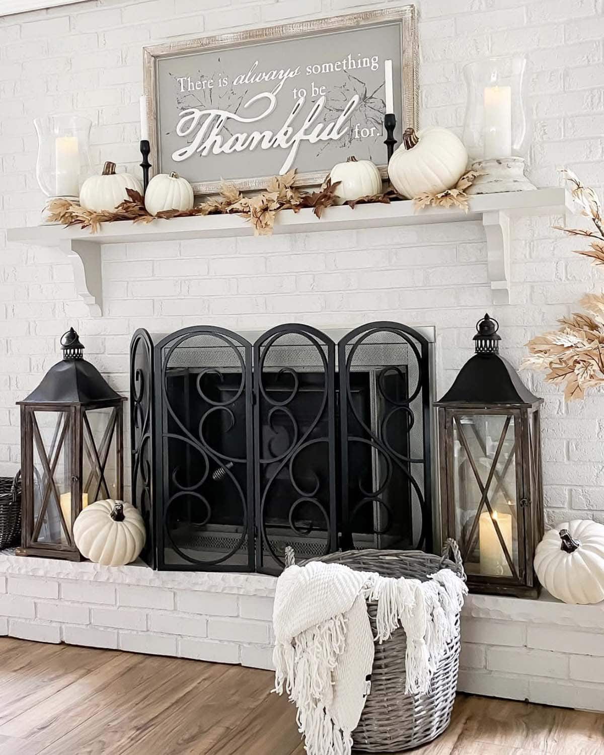 fireplace decorated for fall with lanterns and pumpkins