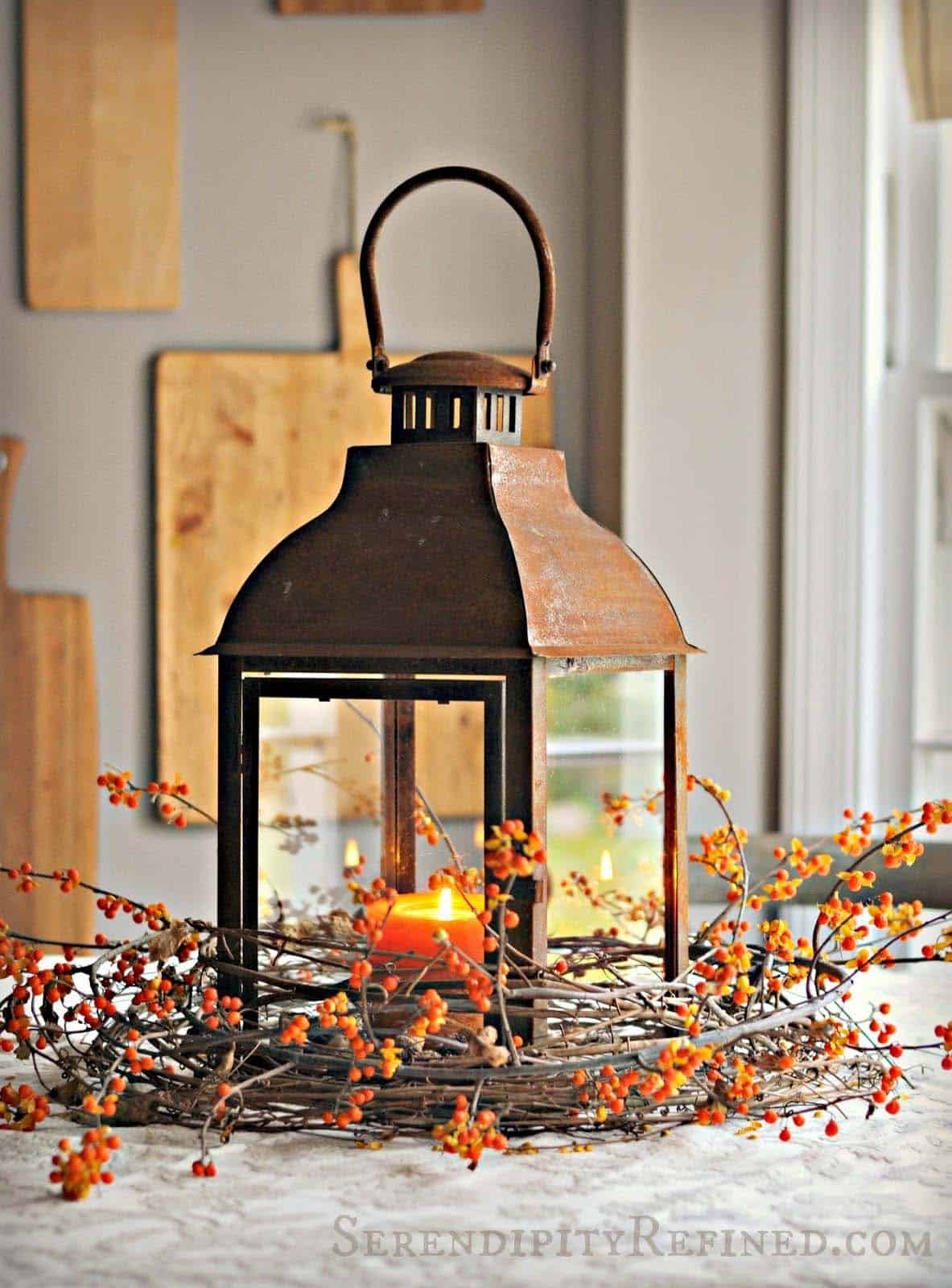 fall table centerpiece with a rustic lantern and bittersweet