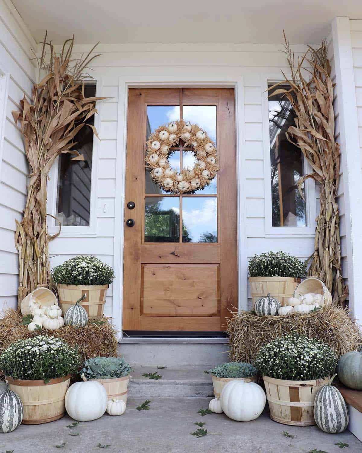 front porch decorated with pumpkins and mums
