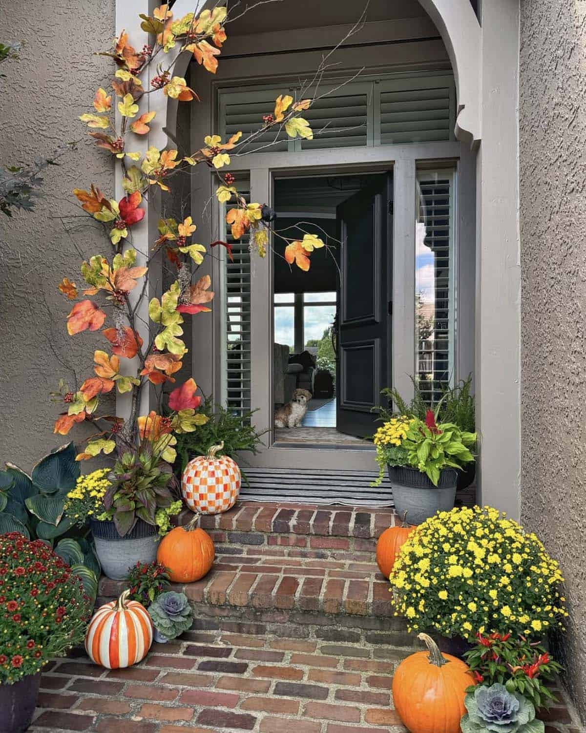 fall front porch decor with pumpkins and fall leaves