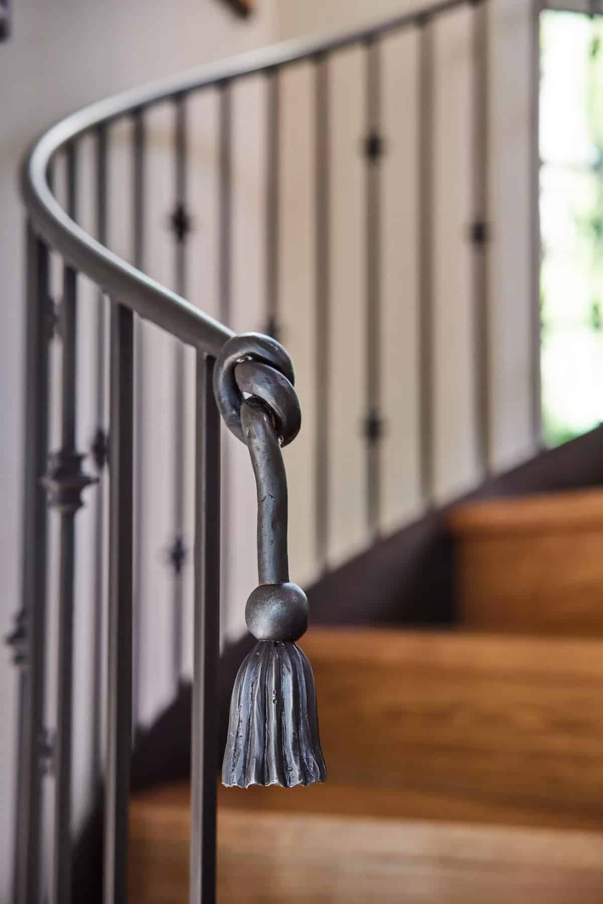 stone cottage with a glassy atrium and spiral staircase handrail detail