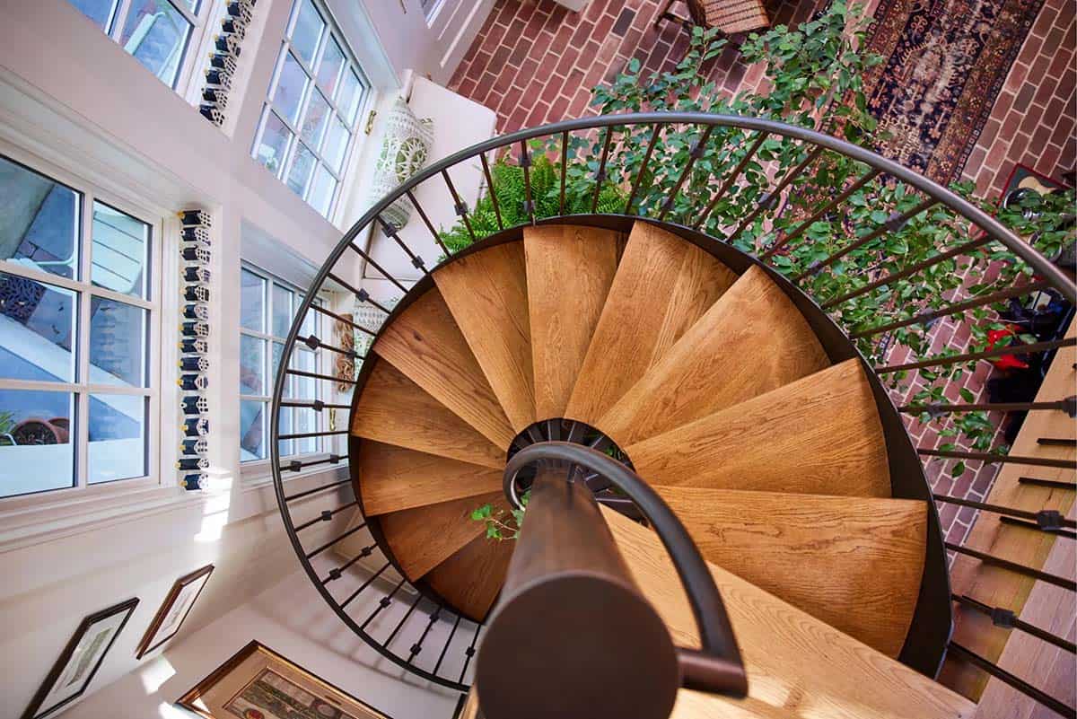 stone cottage with a glassy atrium and spiral staircase