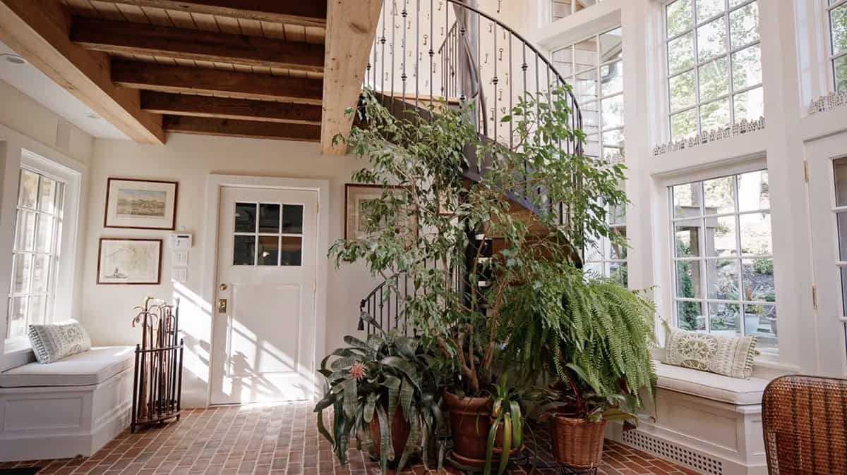 stone cottage with a glassy atrium and spiral staircase