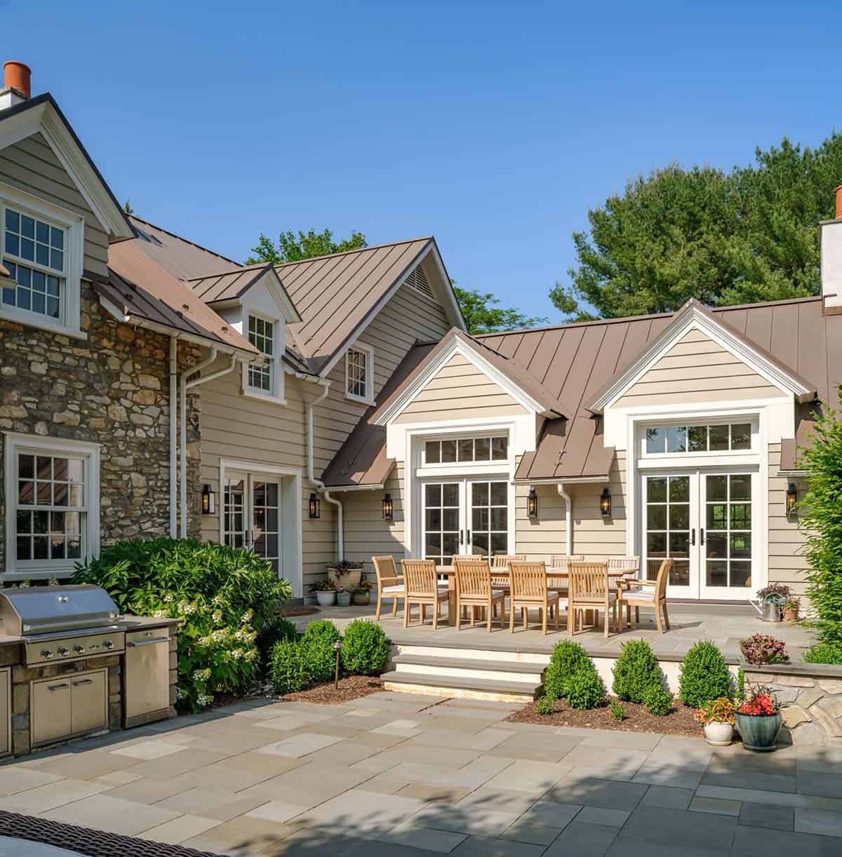 stone house exterior with a patio and a grill