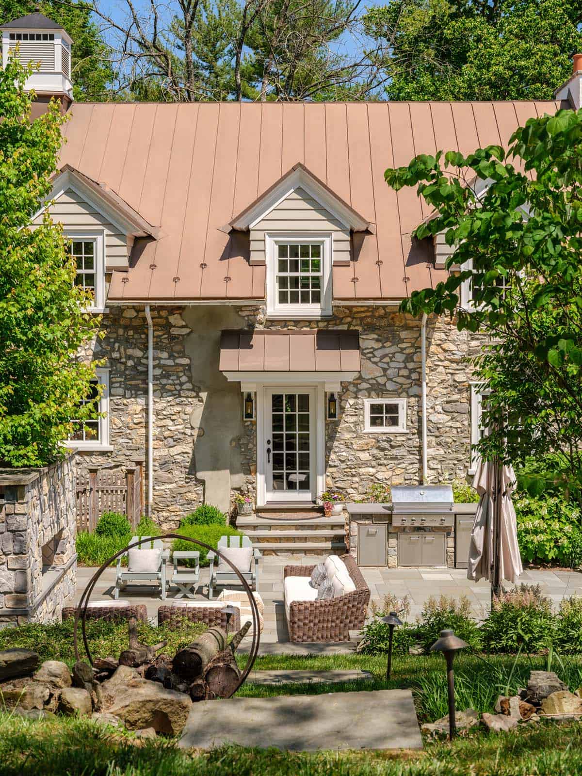stone house exterior with a patio and outdoor furniture