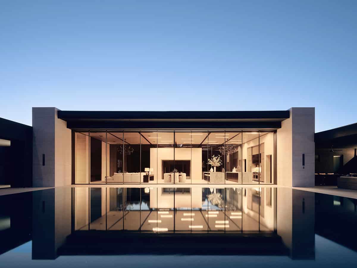modern mountain home exterior with a pool at dusk