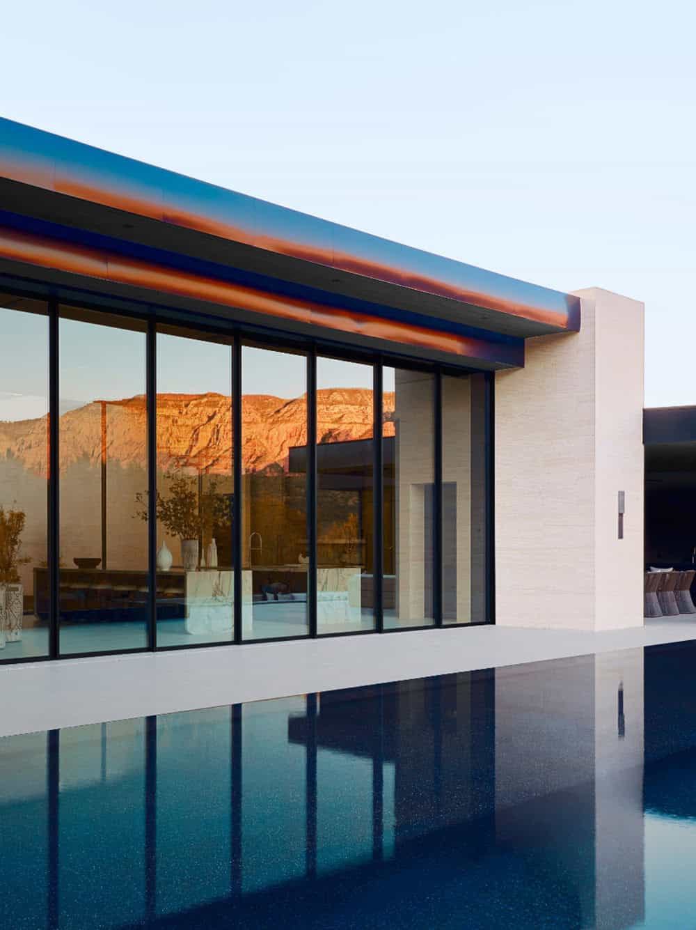 modern mountain home exterior with a pool at dusk