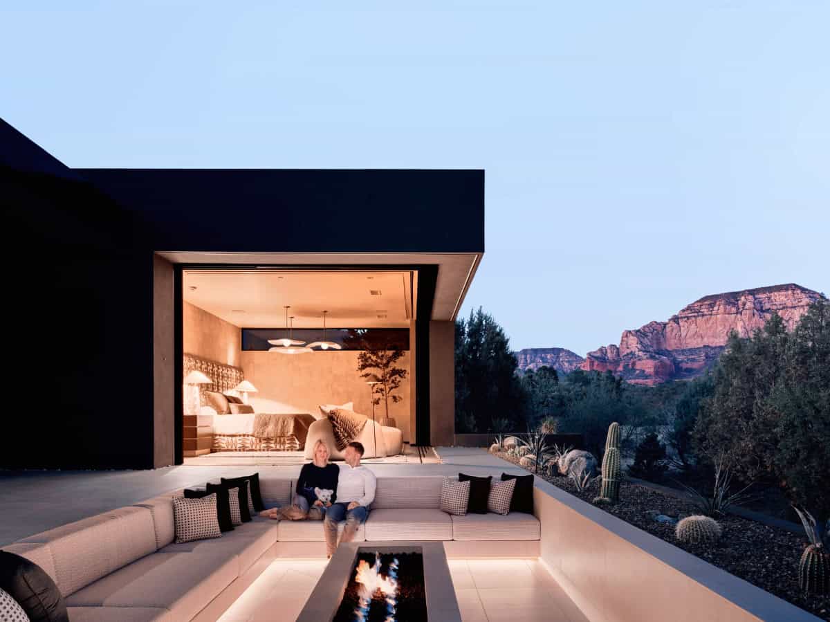 modern mountain home exterior patio with a fire pit at dusk