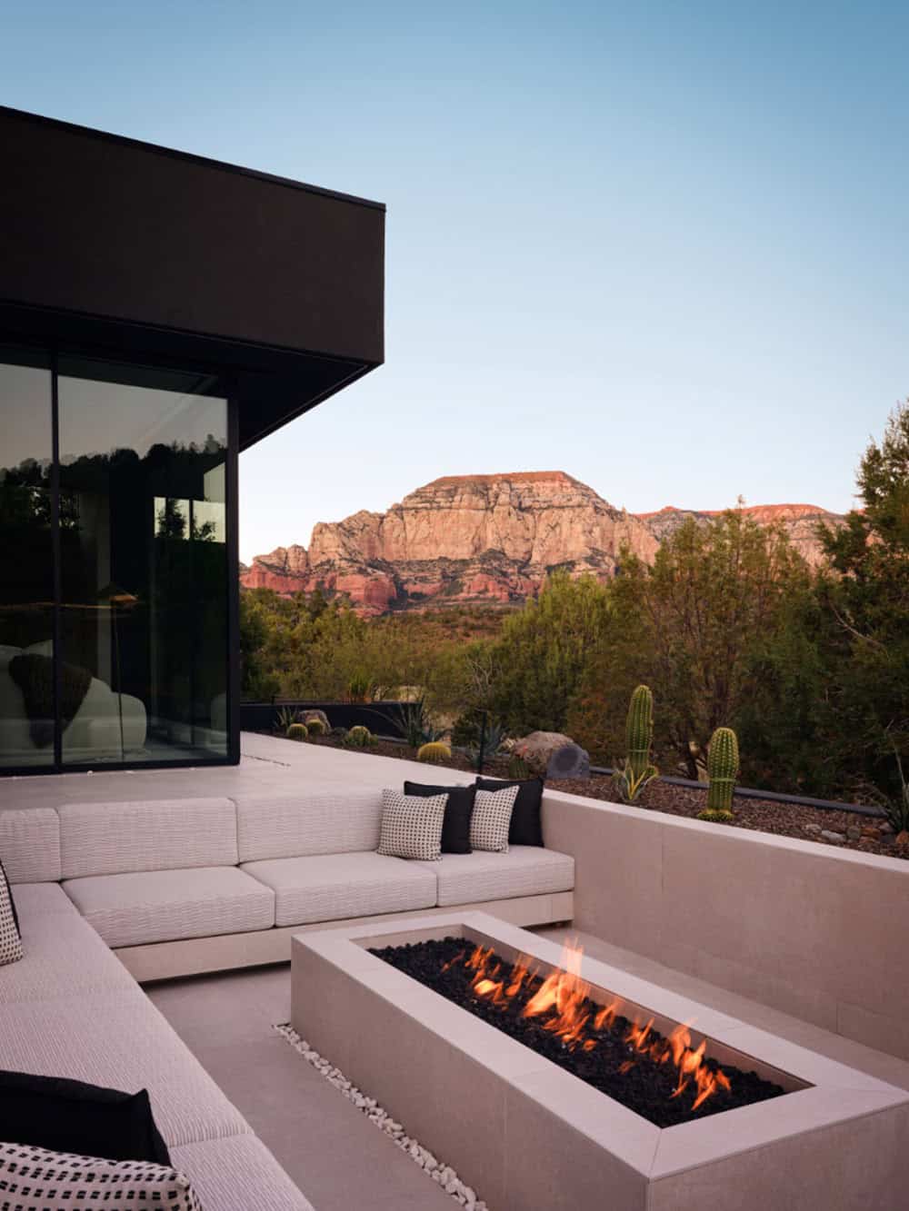 modern mountain home exterior patio with a fire pit at dusk