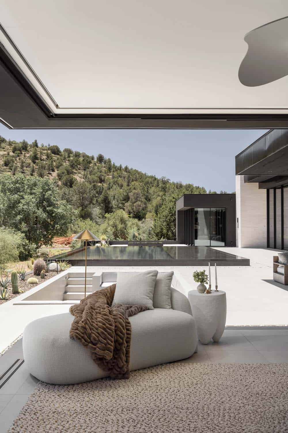 modern bedroom with a sitting area and walls of disappearing glass