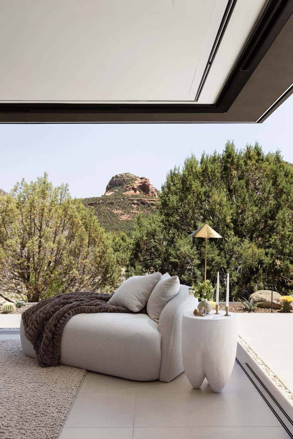 modern bedroom with a sitting area and walls of disappearing glass