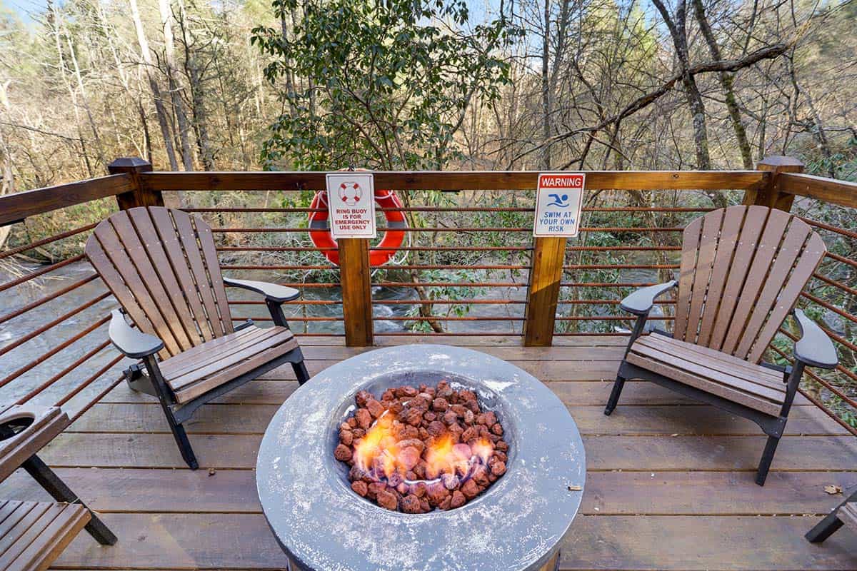 modern rustic log frame cabin porch with a fire pit