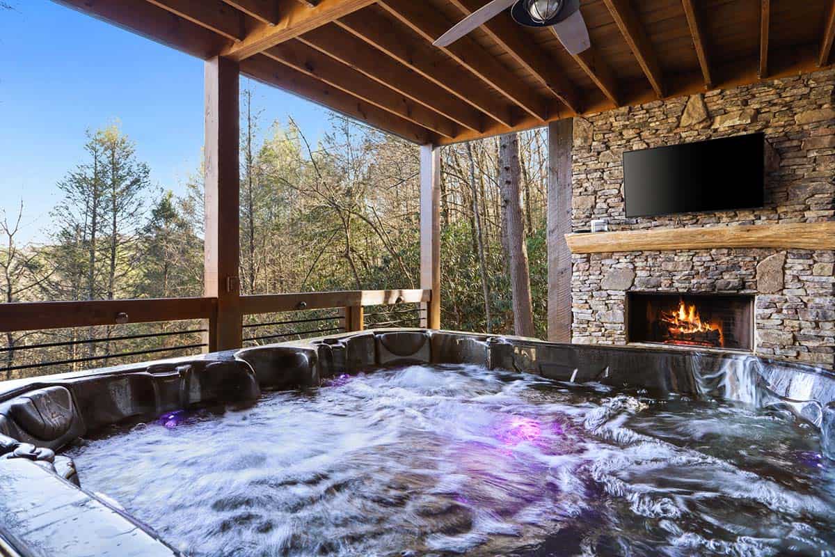 modern rustic log frame cabin porch with a hot tub