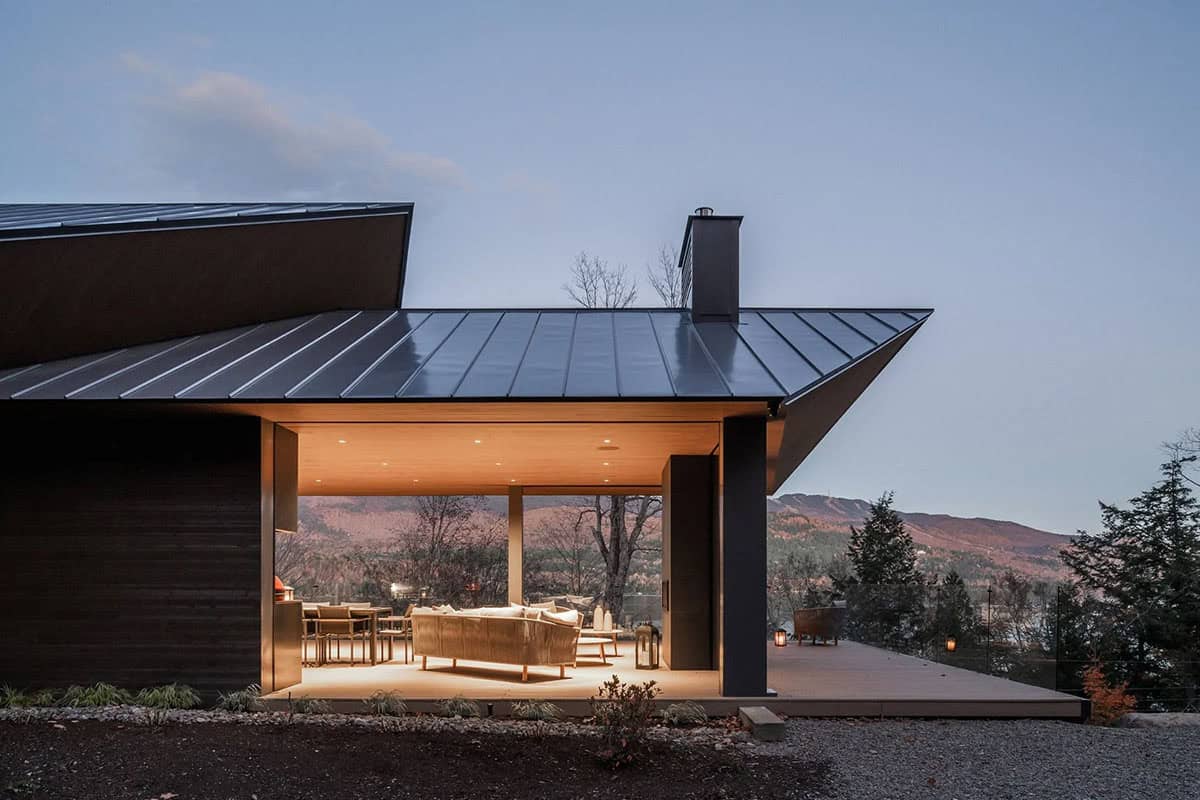 mountain house exterior with a covered patio at dusk