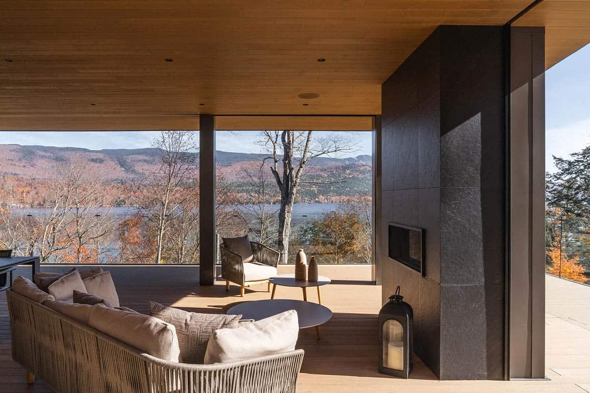 modern covered porch with a fireplace and lake views