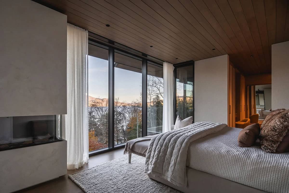 modern bedroom with a fireplace and large windows