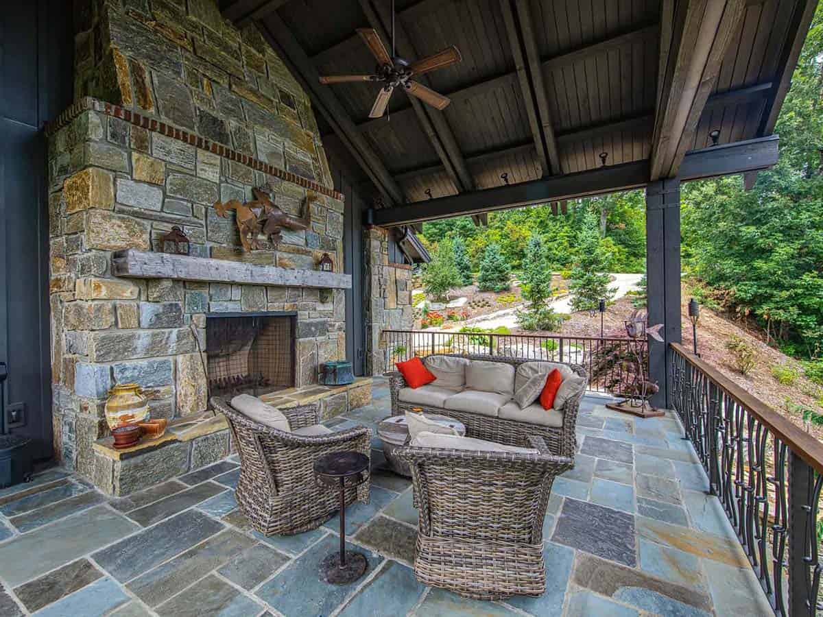 mountain ranch style home exteiror with a covered patio and fireplace