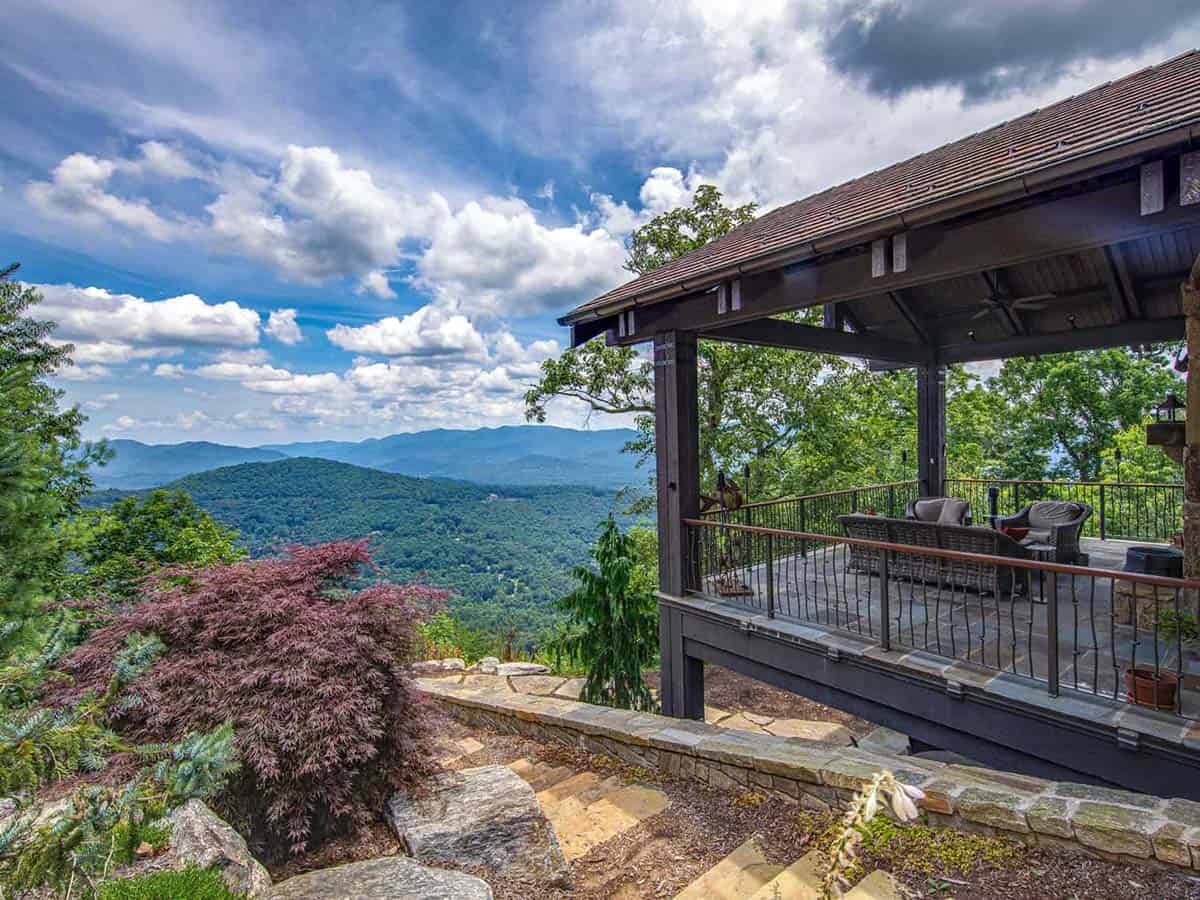 mountain ranch style home exteiror with a covered patio
