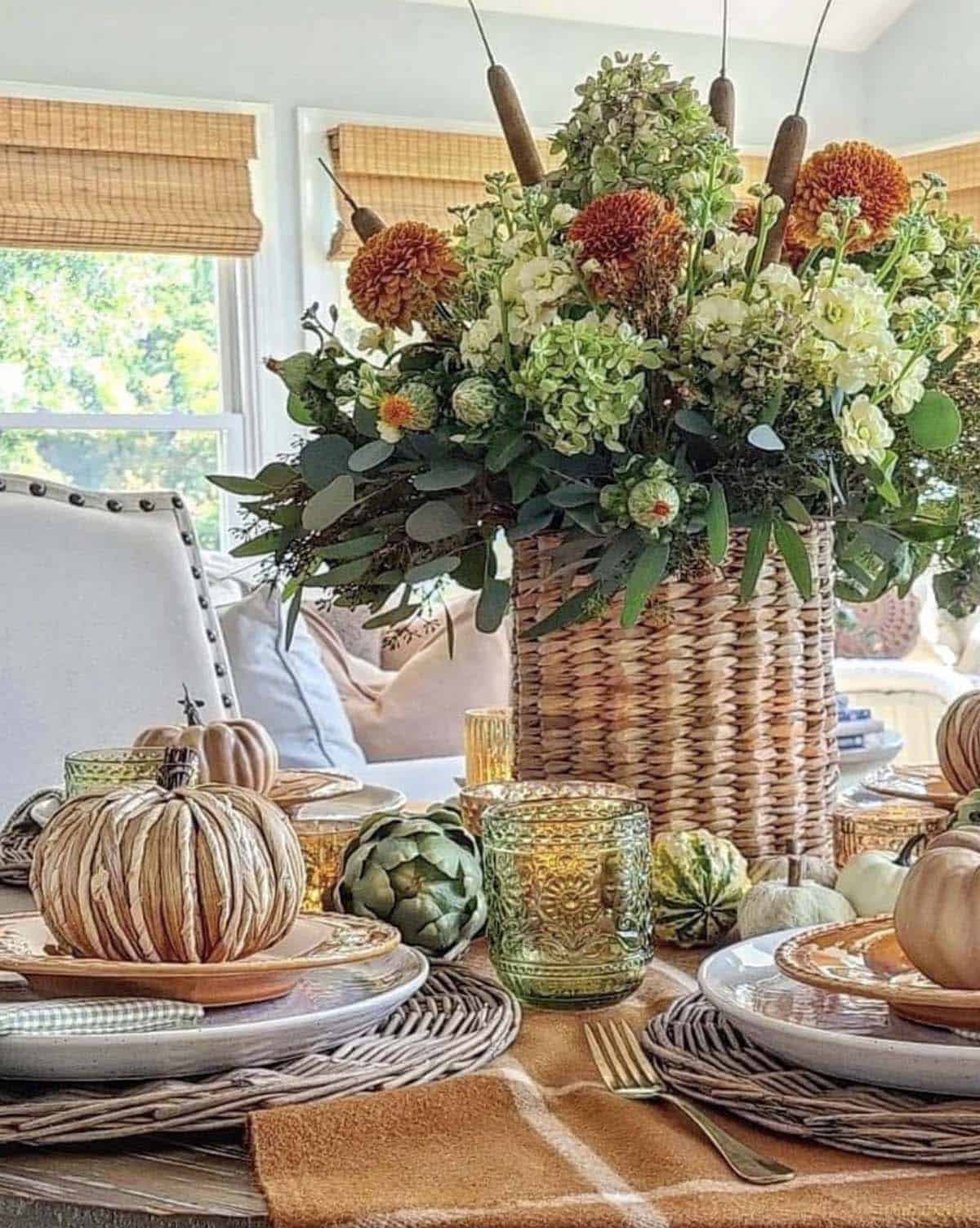 fall decorated dining table with a floral arrangement in a basket