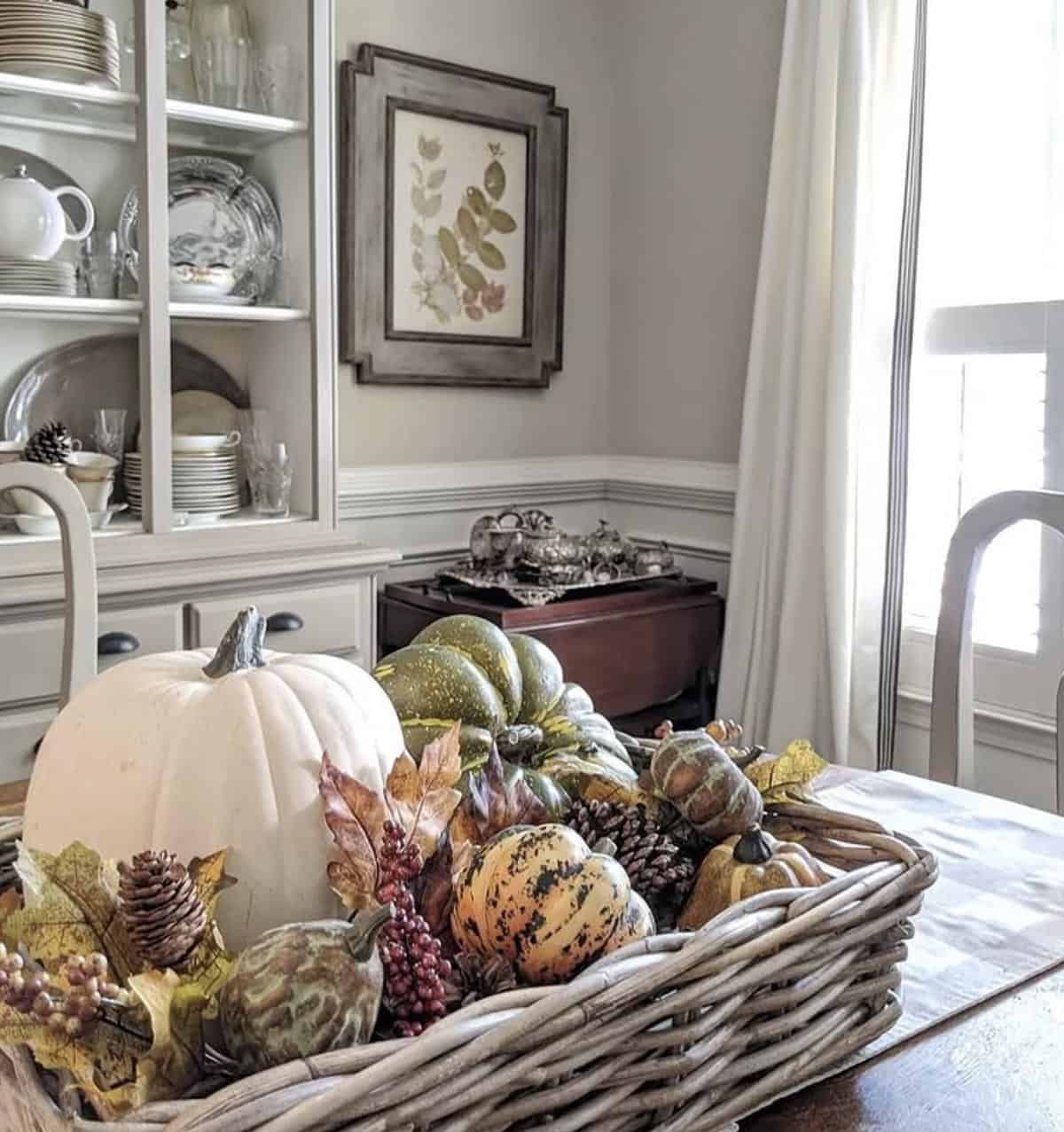 fall dining table with a rustic basket centerpiece filled with pumpkins and gourds