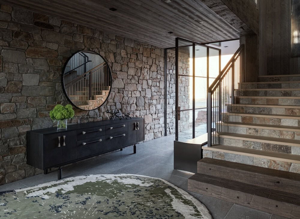 modern mountain style home entry with a console table and staircase