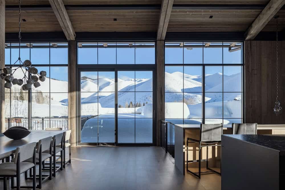 modern mountain style dining room and kitchen with a large window