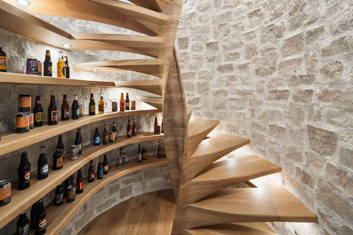 modern wine cellar with stone walls and a spiral wood staircase