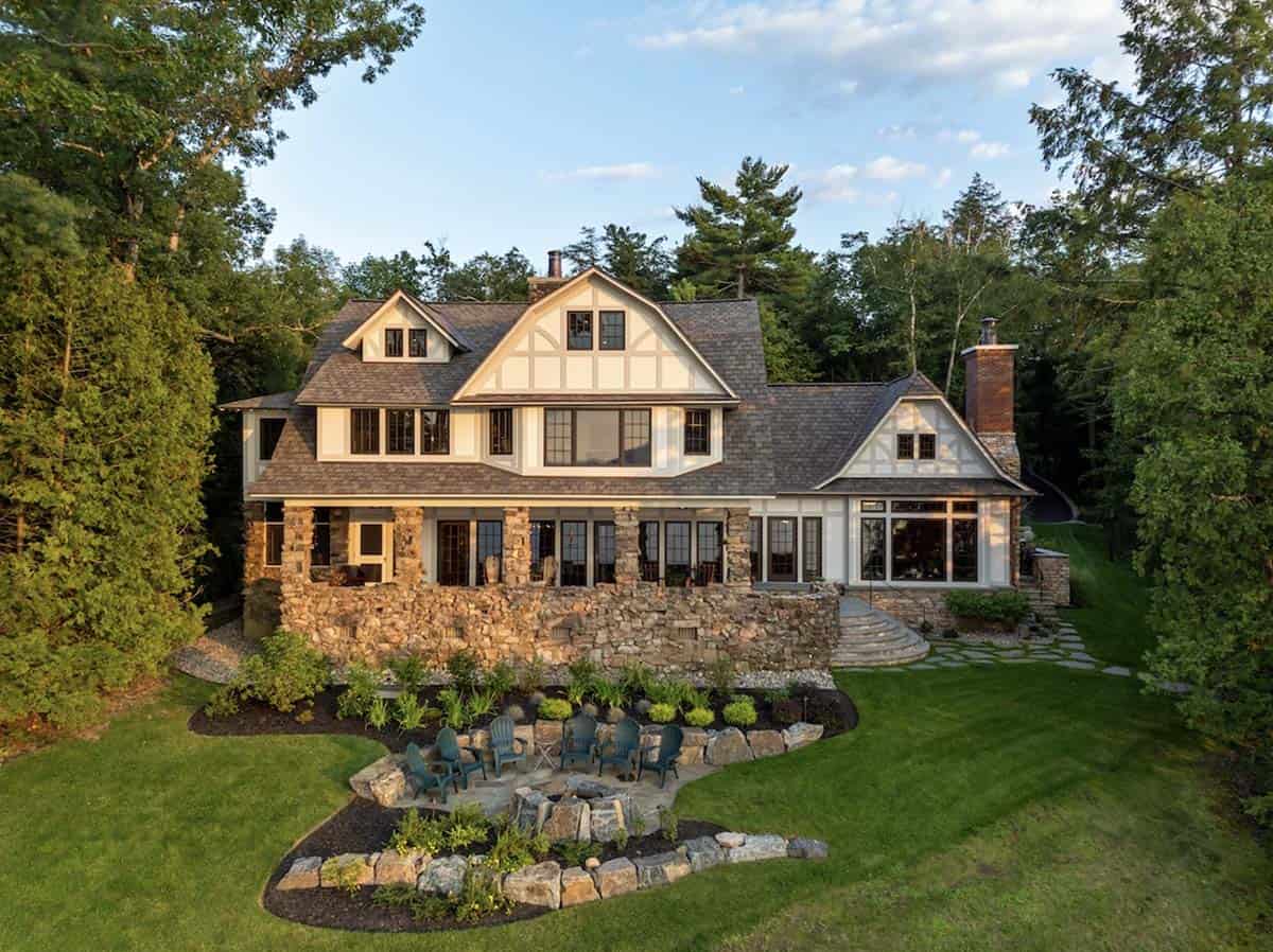 tudor style lake house exterior with a fire pit 
