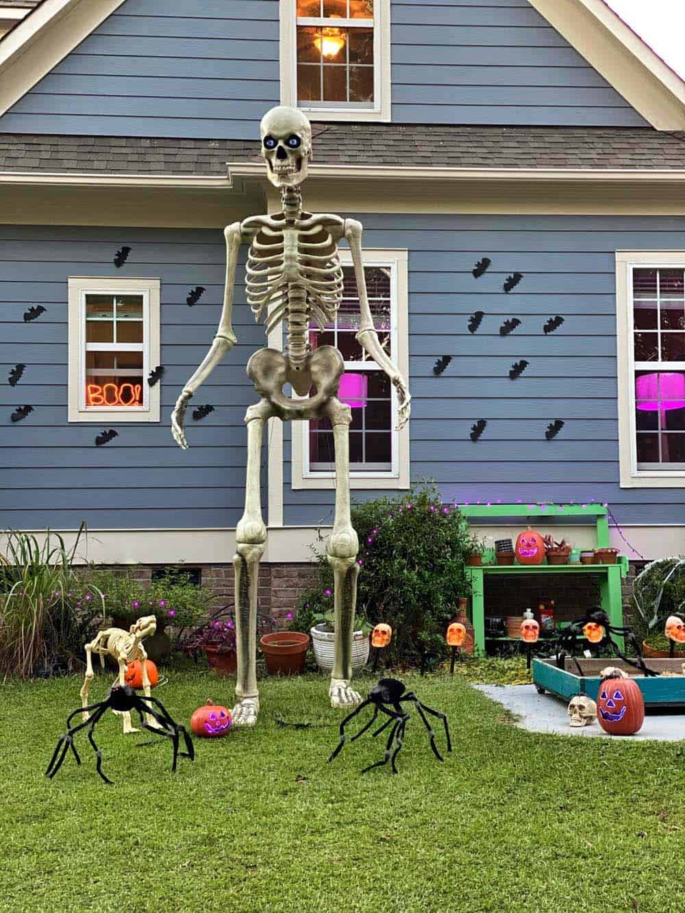 outdoor haloween decor with a huge skeleton and spiders