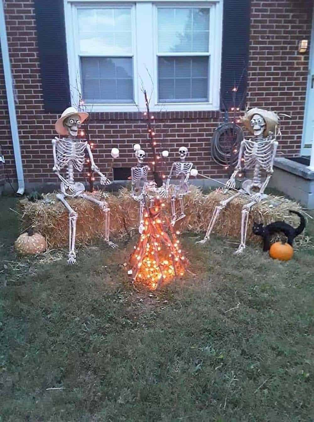 outdoor halloween decorating with skeletons around a bonfire having a party