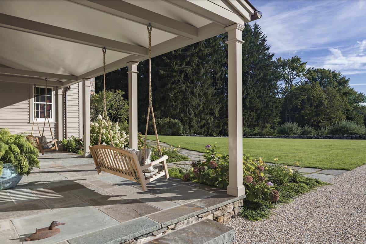 stone farmhouse exterior front porch with a swing