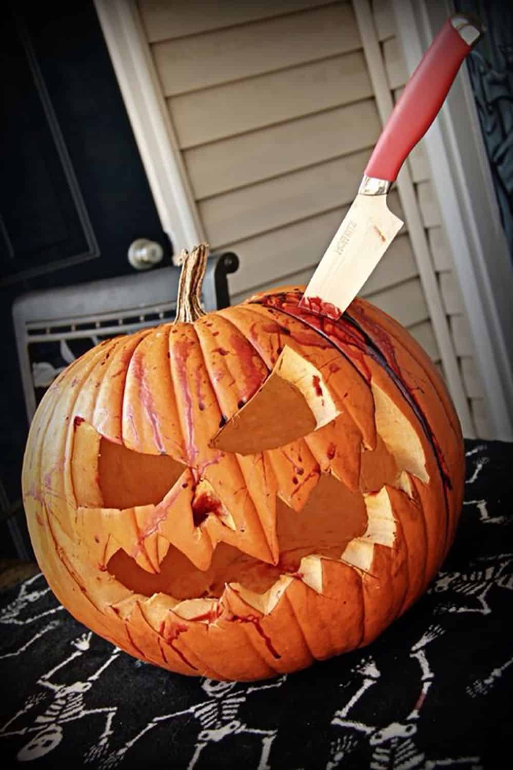 carved Halloween pumpkin with a knife in its head