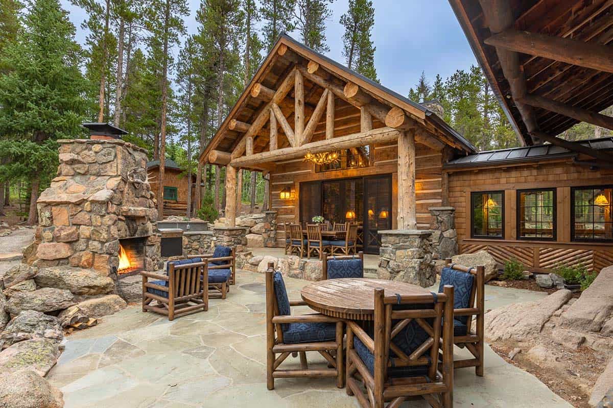 log cabin exterior with a patio with outdoor furniture and a fireplace