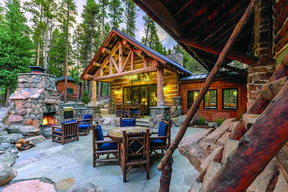 log cabin exterior with a patio with outdoor furniture and a fireplace