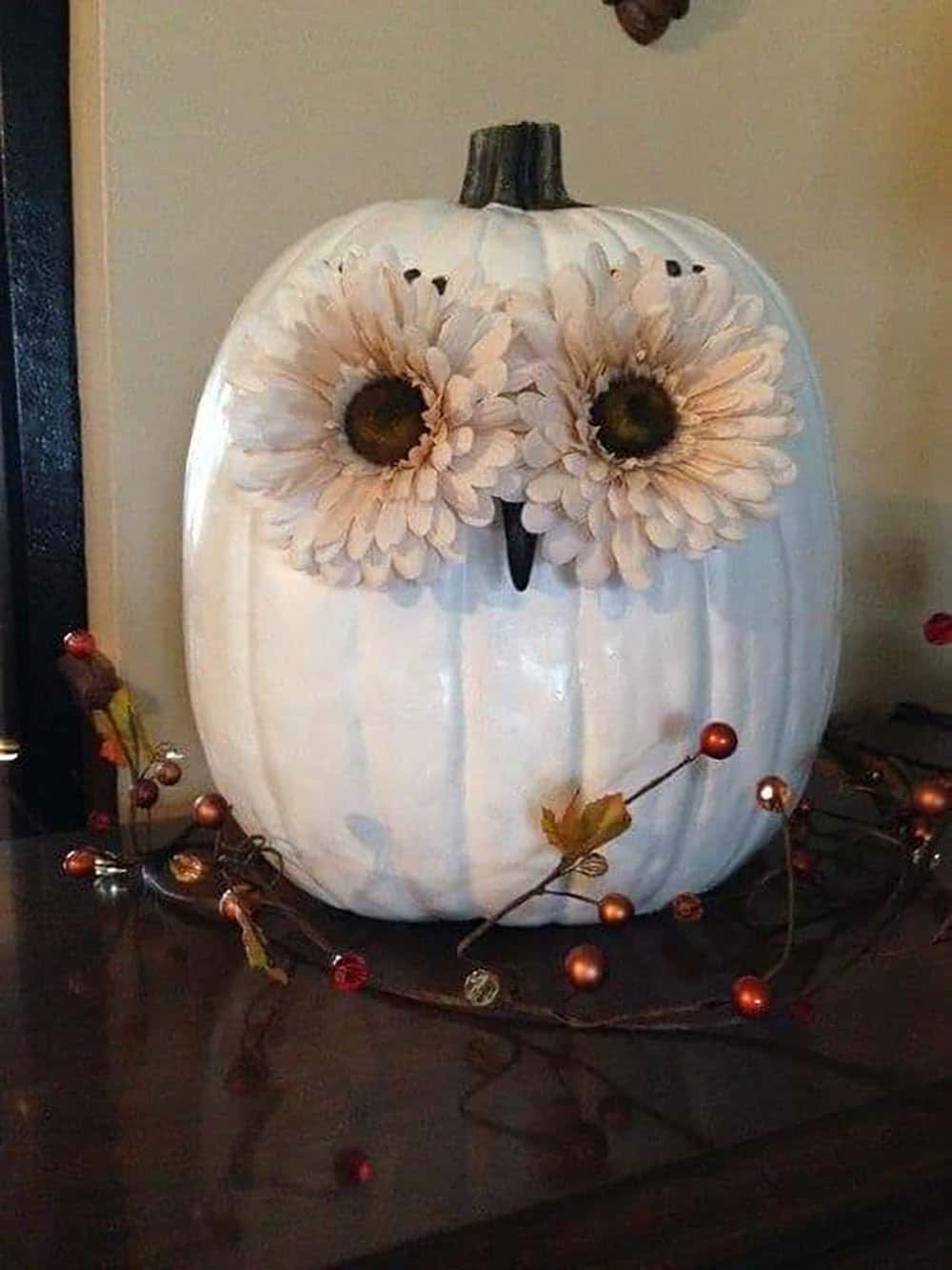 painted white owl pumpkin with faux flowers for eyes