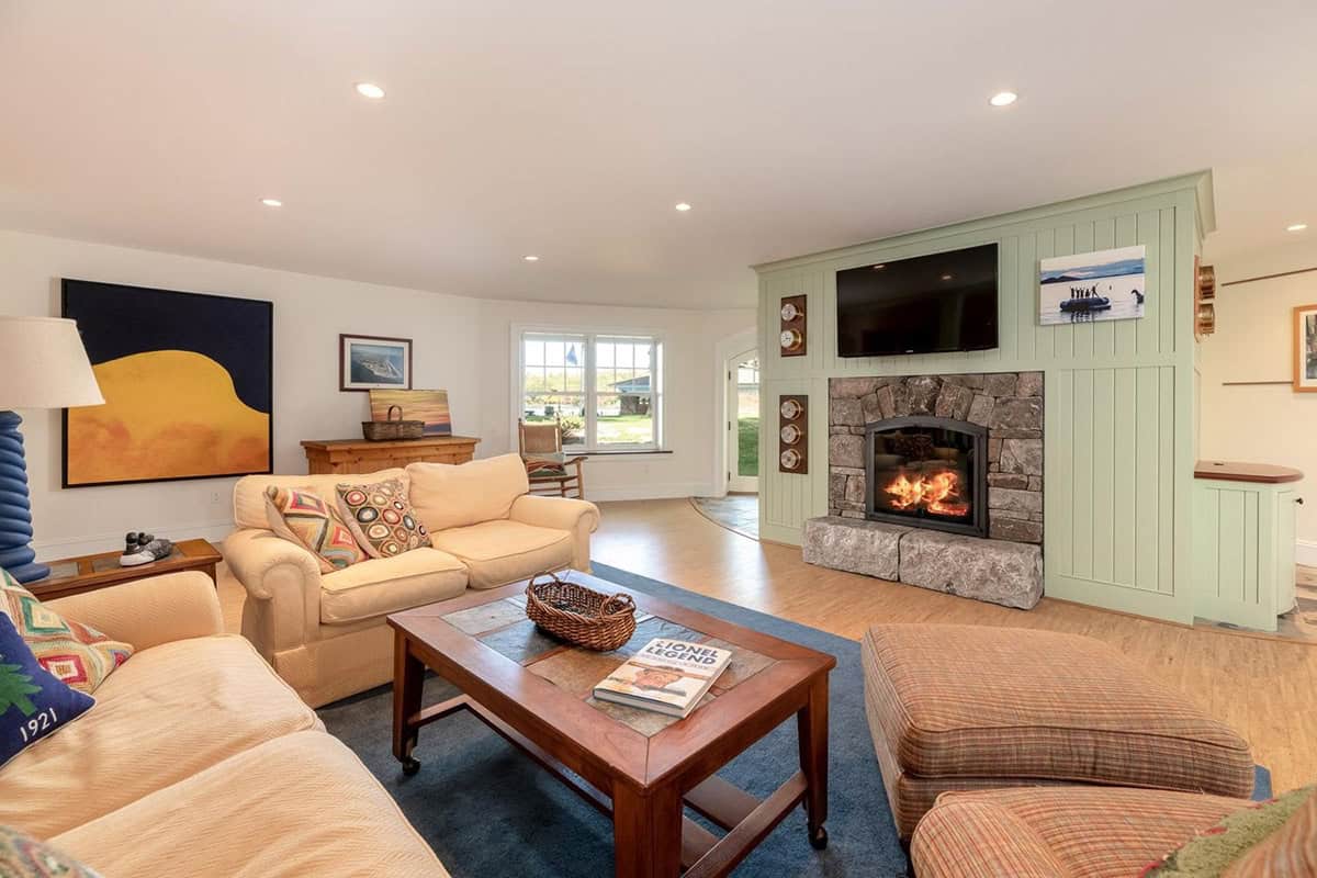 coastal style lower level family room with a fireplace