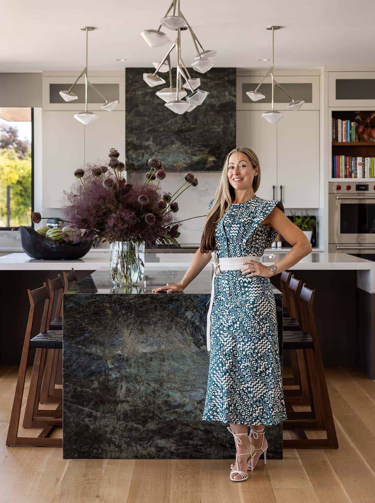 An elegant woman standing in a modern kitchen with a large island