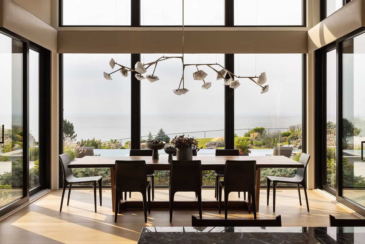 modern dining room with large windows, ocean view and sculptural lighting