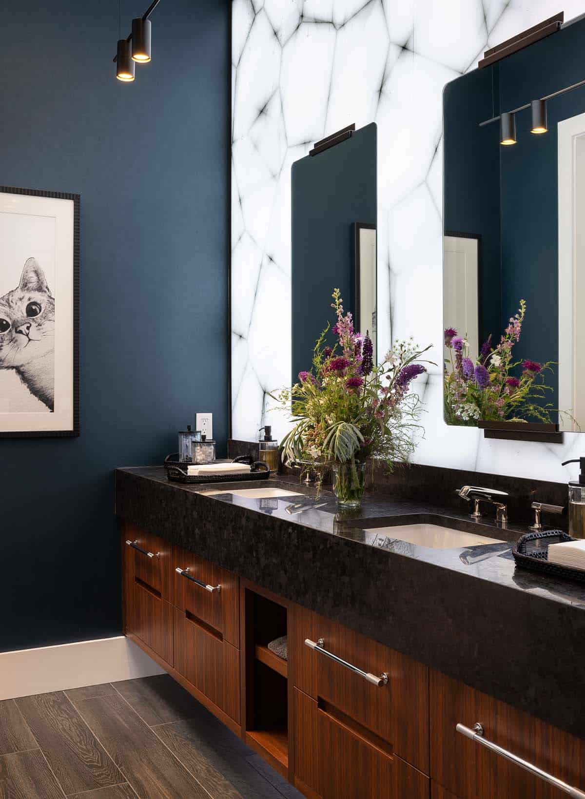 modern powder room with a backlit stone wall and wood vanity
