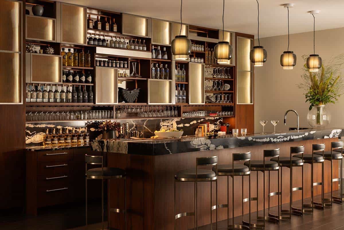 modern home bar with cococabana stone and walnut cabinets