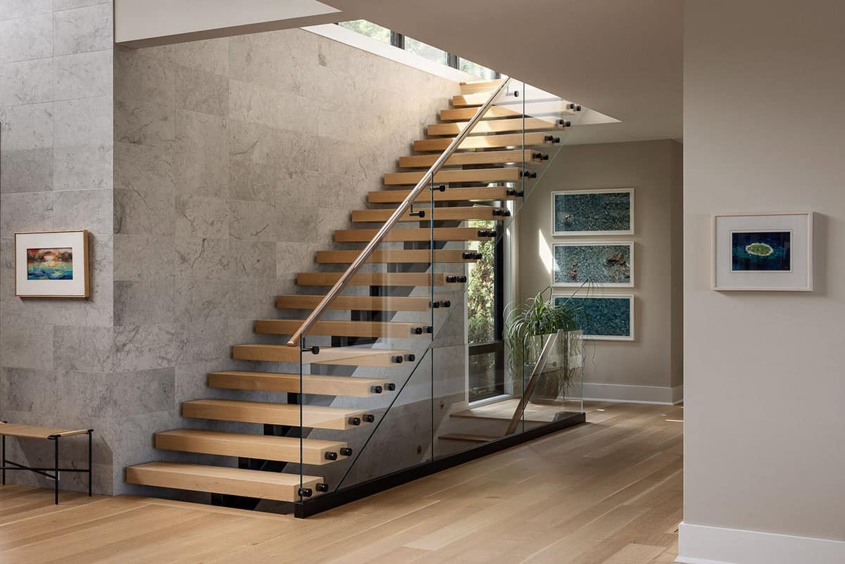floating staircase, glass railing and limestone wall