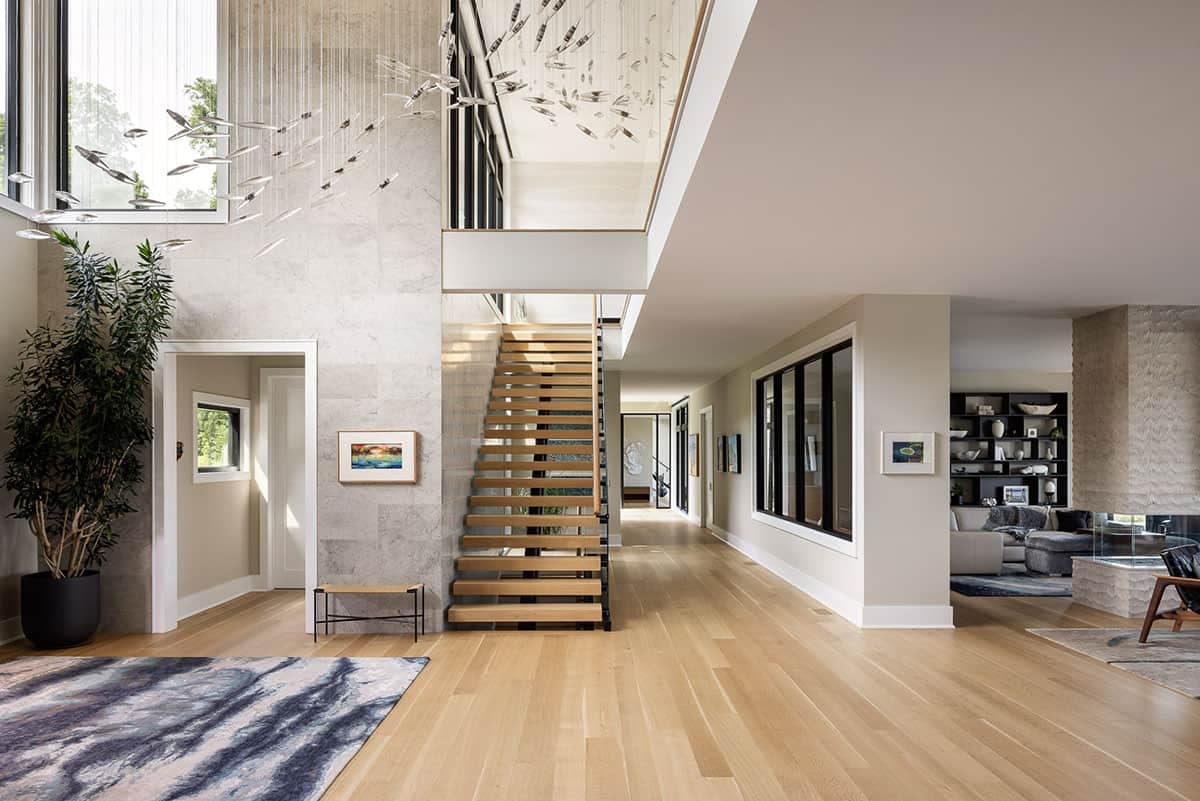 main hallway with a floating staircase and light-filled interior