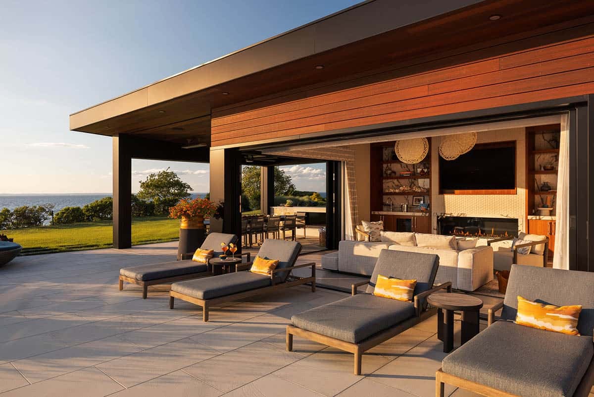 modern pool house with a fireplace and chaise lounges