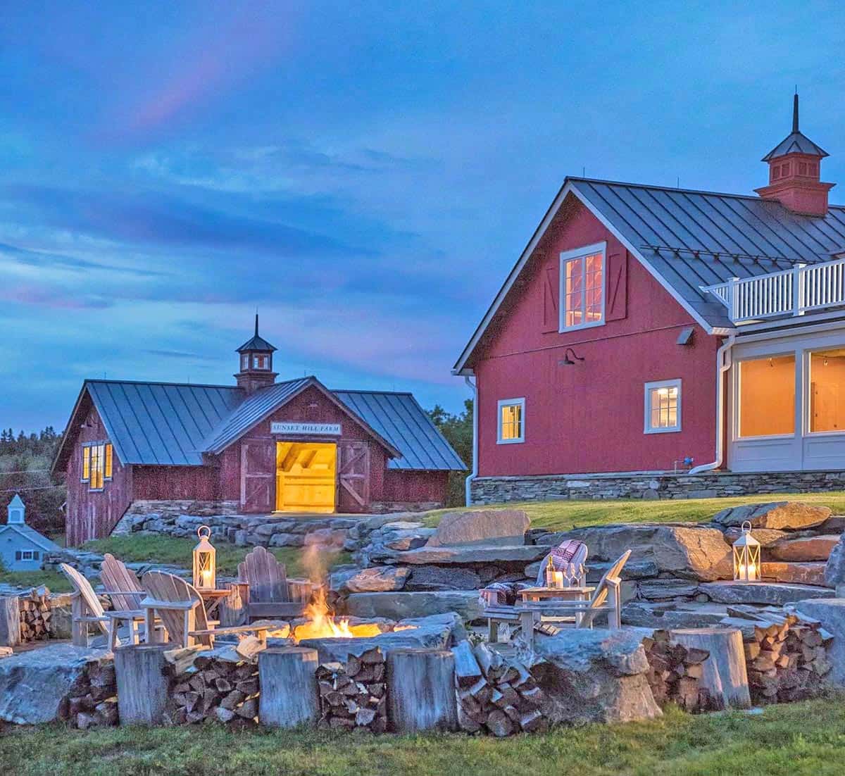 modern farmhouse style home exterior with a patio and fire pit at dusk